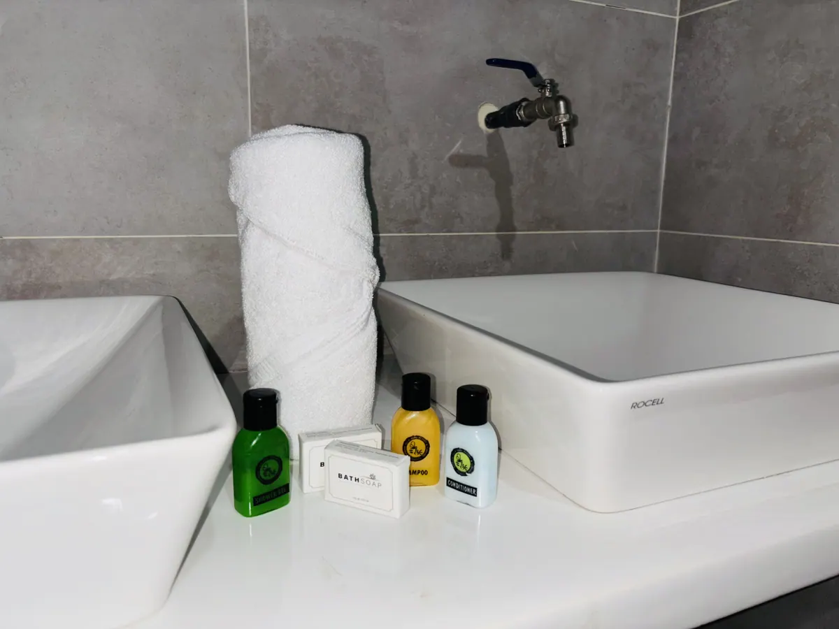 Two stone basins in the campsite washroom, with towels and toiletries