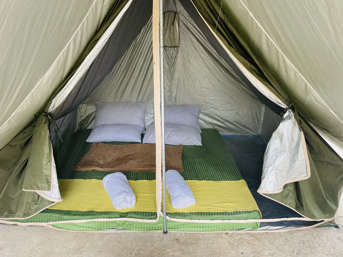 Inside a ridge tent: two mattresses with pillows and rolled towels