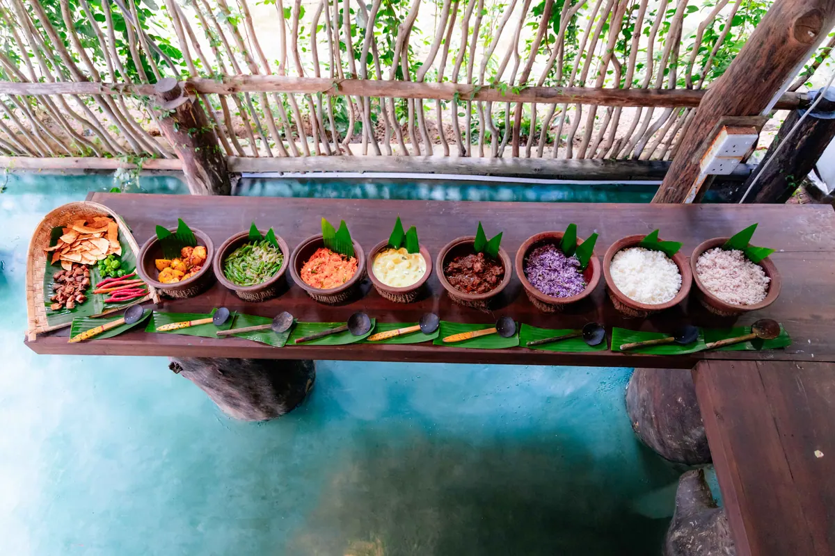 Clay pots of rice and curry laid out along the table in the open-air dining room