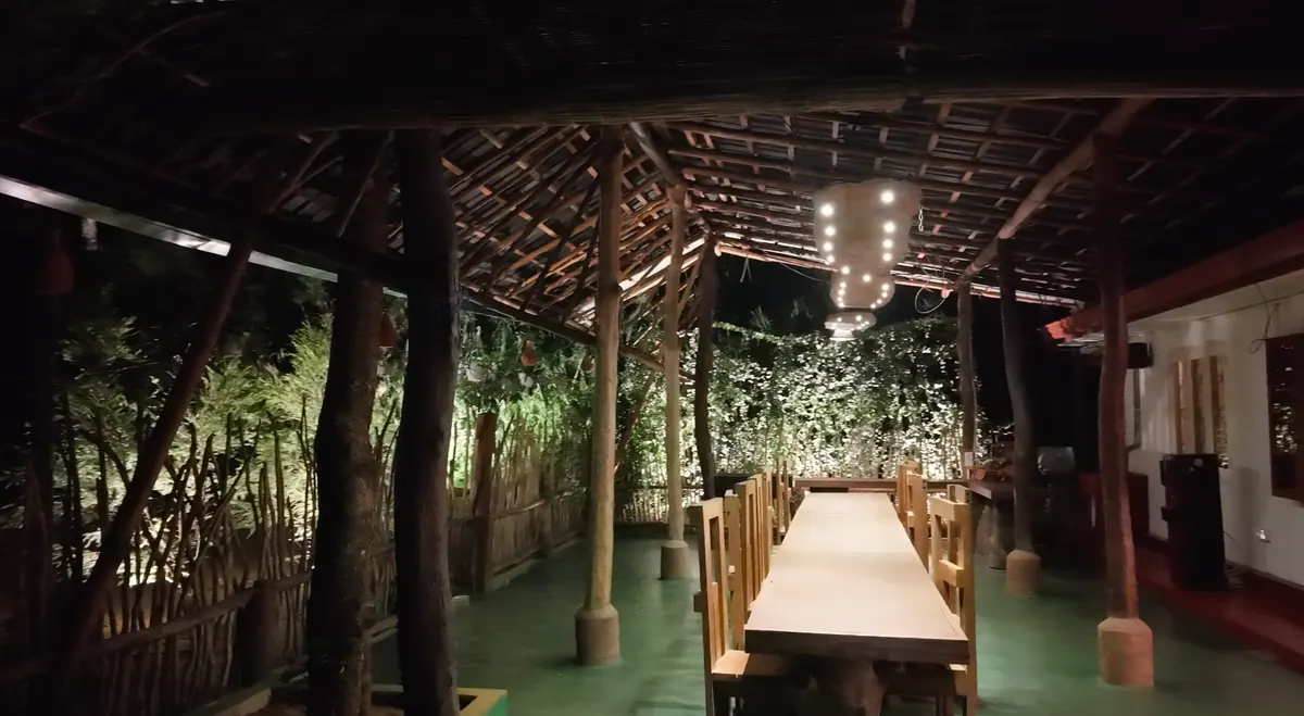 The veranda at night, the long table lit under strings of lights