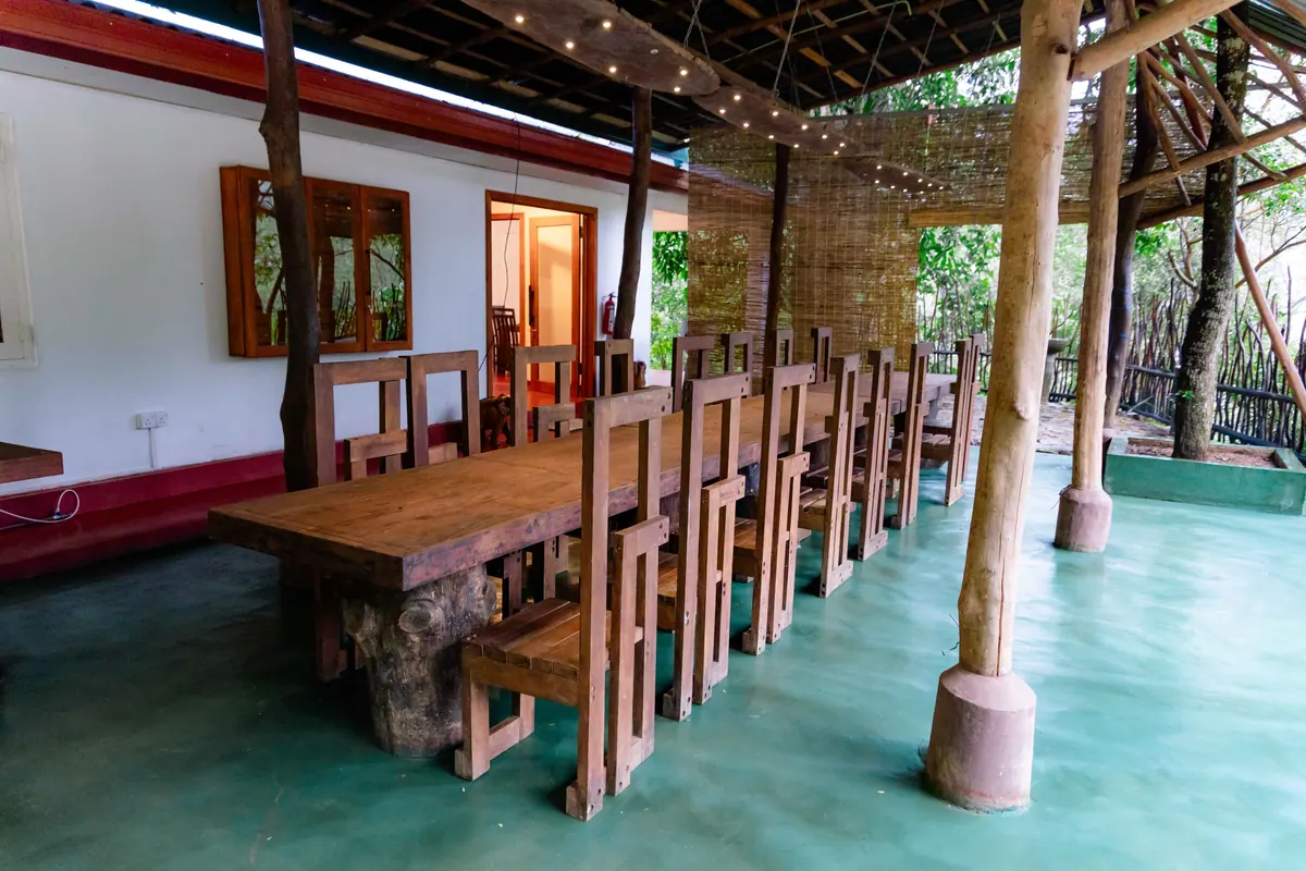 The farmhouse veranda: a long wooden table and chairs between timber posts